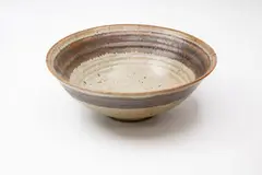 Stoneware bowl by Margaret Milne, decorated with a band of saturated iron glaze around the rim on a grey ash glaze, sold Feb 2024