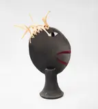 Stewart Fulljames, Stylized figure with mohawk, matte black earthenware with incised glazed features and attached flax