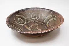 Una Sharpley, Large stoneware bowl, with iron glaze decorated with wax resist spirals and star design