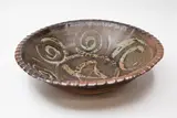 Una Sharpley, Large stoneware bowl, with iron glaze decorated with wax resist spirals and star design