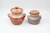 Andrew van der Putten, Two stoneware handled jars, the first with ceramic lid and crackle shino glaze with reddish tones, the second with a light toned shino glaze and cork stopper (one with hairline)