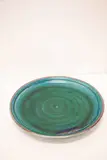 Large and impressive charger by Graeme Storm, stoneware with aqua green glaze with darker highlights and brown rim, pierced to the foot ring for wall suspension, sold Feb 2024