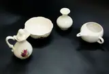 Collection of four small white pieces by Crown Lynn Potteries, including a rose pattern oil jug and powder bowl; a hospital feeder mug and a Titian vase, offered Feb 2024