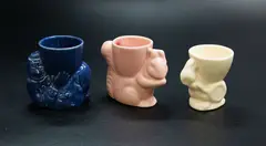 Three egg cups by Crown Lynn Potteries, comprising a blue clown, a pink squirrel and a white rabbit, sold Feb 2024