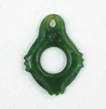 Kāka pōria, 19th century pounamu bird leg ring, Central hole, and a smaller hole drilled near top edge. Outer edge stone circle has 3 sets of stone protrusions, bottom and side edges of ring. Entire surface well polished and worn smooth.