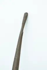 Kō, Digging Stick, Long carved medium brown pole tapering to a point at one end the other a narrow blunt end, split in the wood near blunt end