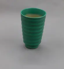 Matt green ribbed vase by Keith Murray for Wedgwood, with flared sides, raised on a foot, shape no. 4314, sold Oct 2023
