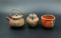 Trio of anagama vessels by Chester Nealie, comprising of a large cup, a small teapot and a small ginger jar, all wood-fired earthenware, partial glaze and textured, sold Oct 2023