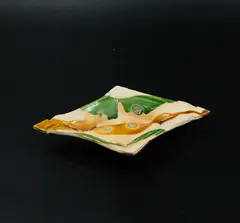 Three-footed diamond dish by Richard Parker, earthenware dish of diamond form with drizzled green and gold glaze, the feet shaped as claws, sold Oct 2023