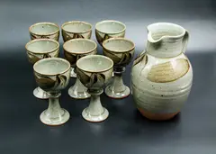 David Lloyd Jones, Pitcher & Goblets, stoneware, comprising one pitcher and eight goblets, mottled sage green glaze with foliage motif