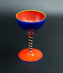 Goblet by Giovanni Glass, blown glass in orange, blue, and yellow with an opaque effect, stripy stem with floral finial, sold Oct 2023
