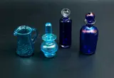 Selection of three perfume bottles and one jug by John Abbott, Lesley Justin, and others, offered Oct 2023