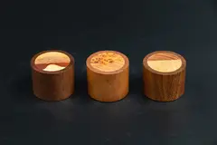 Paul Mason, Trio of paperweights, carved wood outer inlaid with different wood grains, arranged to create delicate motifs, cork base