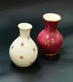 Two small flower vases attributed to Daniel Steenstra by Crown Lynn Potteries, the first of pear shape with roses on a white ground, the second of baluster form with berry and leaf pattern on a magen, offered Oct 2023