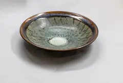 Stoneware bowl by Graeme Storm, with wax resist green decoration over an iron glaze ground, offered Oct 2023