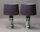 Fornasetti, Viso lamps, a pair of cylindrical metal lamps with hand-silkscreen design featuring the face of Lina Cavalieri, with brass detailing and black shades