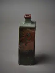 A square sided bottle vase by Len Castle, in tenmoku glaze with wax resist decoration, sold Mar 2023
