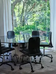 Ron Sang, A contemporary dining table, circular plate glass top with steel, drum base