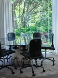 Ron Sang, A contemporary dining table, circular plate glass top with steel, drum base