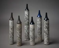 Six ‘Candle’ vases by Margaret Milne, each with deep blue glazed spire necks, sold Mar 2023