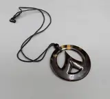 Steve Myhre, Small faux turtle shell pendant, faux turtle shell pendant of round shape with pinnacle form in its centre, cord necklace
