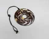Steve Myhre, Large faux turtle shell pendant, cord necklace, faux turtle shell pendant of round shape decorated with whirling chevrons