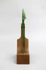 Al Brown, Pounamu leaf-shaped hairpin, mottled translucid greenstone on carved wooden stand