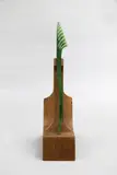 Al Brown, Pounamu leaf-shaped hairpin, mottled translucid greenstone on carved wooden stand