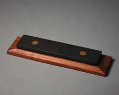 Grindstone by John Edgar, granite with copper inserts on wooden stand, 1992, sold Sep 2022