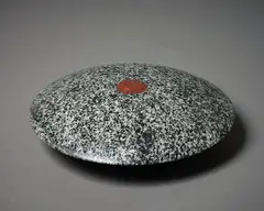 Lens by John Edgar, carved and inlaid tonalite lalitpur granite, Coromandel, sold Sep 2022