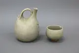 Pale celadon pourer and cup by Len Castle, stoneware with crackled glaze, sold Jun 2022