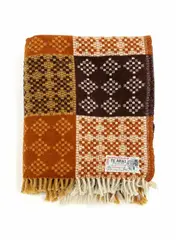 Onehunga Woollen Mills, Te Ariki travel rug, with a tukutuku panel pattern in orange-brown, dark brown, mustard yellow and white (A/F)