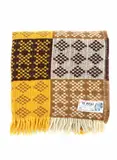 Onehunga Woollen Mills, Te Ariki travel rug, with a tukutuku panel pattern in yellow, light brown, dark brown and white