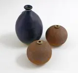 A collection of three small stoneware vases by Len Castle, including a purple glazed bottle vase and two umber pigmented spherical vases, sold Nov 2021