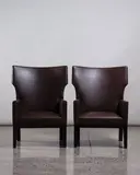 Christian Liaigre, A pair of Barbuda armchairs, with dark brown leather upholstery, wooden bases