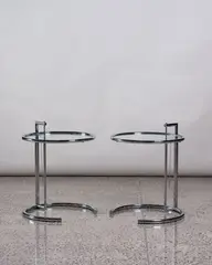 Eileen Grey, Pair of E1027 adjustable side tables, made by ClassiCon and authorised by Aram Design, chrome tubular steel framing with glass circular top