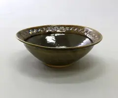 Large bowl by Barry Brickell, ash glazed stoneware, the upper rim with jun glaze splashes over interlaced relief pattern, sold Dec 2020