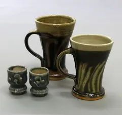 Mashiko Pottery, Two matched mugs in the style of Hamada Shoji, stoneware with wax-resist decoration; together with a pair of wine cups in the manner of Kawai Kanjiro