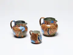 Frederick Rhead, Three Bursley Ware Amstel jugs, painted ceramic with bird decoration