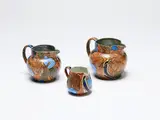 Frederick Rhead, Three Bursley Ware Amstel jugs, painted ceramic with bird decoration