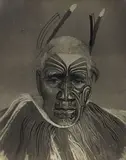 A black and white photograph of the Maori Chief Tuhawaiki by Theodorus Johannes Schoon, hand-coloured by Schoon, ink on vintage gelatin silver print, sold Jun 2017