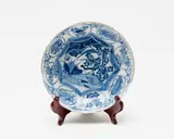 Kangxi period by A small Chinese blue and white saucer dish, with barbed rim, painted to the centre with a duck on a lotus pond, the cavetto with panels with auspicious symbols, sold Sep 2016