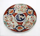 A large Japanese Imari dish, Meiji period, decorated with panels of phoenix and long tailed birds on blossoming sprays