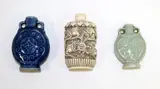 Three Chinese snuff bottles, 20th century, comprising two similar porcelain ones with archaistic decoration, and a faux ivory one carved with Buddhist lions