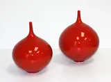 Peter Collis, Two red glazed bottle vases, with spire necks