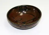 Len Castle, Stoneware bowl, with tenmoku glaze and wax resist quince blossom decoration