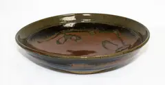 Stoneware bowl by Len Castle, tenmoku glaze with wax resist quince blossom decoration, sold Mar 2015