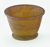 A Chinese turned rhinocerous cup, 19th century, the slightly flaring sides issuing from a shallow circular solid base to a flat everted rim, two carved parallel lines just below the rim