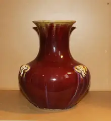 A Chinese flambÃ© baluster vase, 18th/19th Century, the shoulders moulded in relief with three ram heads, covered with a thick crackled streaked glazes of red and purple tones, thinning to mushroom at the rim and to the relief decoration