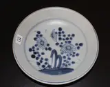 Two Tek Sing cargo blue and white dishes, 19th century, the first painted with a panel of chrysanthemum sprays, the second with shaped panels of stylised floral design
